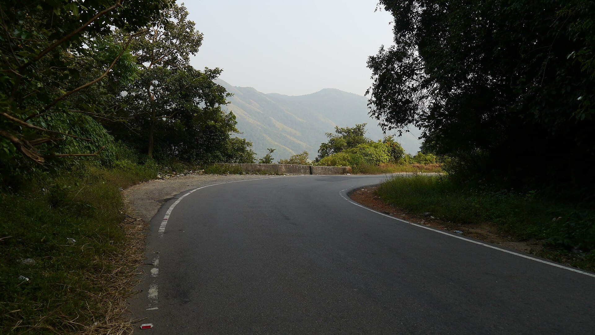Scenic Western Ghats mountain highway curve in Karnataka - RV Tours & Travels fleet